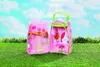 A pink and green playhouse toy is set up on a grassy lawn with a blue sky and clouds in the background. Produktbild-Vorschau