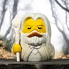 A Gandalf the White duck toy standing on a dark surface with a blurred forest background. Podgląd zdjęcia produktu