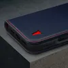 Close-up of a dark blue leather phone case with red stitching and a red bull logo. Produktbild-Vorschau