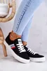 A person wearing jeans and black Lee Cooper sneakers is sitting on a chair. Náhľad obrázku produktu