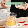 A person is holding a small bowl and a fork with food, demonstrating a food storage container. Náhľad obrázku produktu