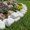Weiße Kieselsteine als Umrandung eines Blumenbeets am Rasenrand im Garten Produktbild-Vorschau