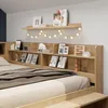 A bedroom scene featuring a bed with a headboard shelf unit. Voir les images du produit