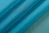 A close-up of folded turquoise fabric, likely a curtain or textile. Produktbild-Vorschau