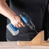 A person is using a cordless drill to drill into a wooden block. Produktbild-Vorschau