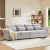 A modern living room with a large gray sofa, a shelf unit with decor, and a window. Produktbild-Vorschau