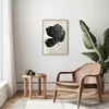 A living room scene with a framed picture on the wall, a chair, and a side table. Produktbild-Vorschau