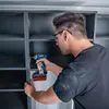 A man is using a cordless drill to assemble a shelving unit. Náhled obrázku produktu
