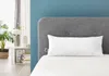 A bedroom scene with a pillow on a bed in front of a headboard. Produktbild-Vorschau