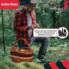A man is in a forest, holding a basket filled with mushrooms. The basket is made of woven material and has a handle. The man is wearing a plaid shirt and a hat. Produktbild-Vorschau