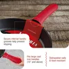 A close-up of a red silicone handle cover on a cast iron pan, with text overlays describing its features. Produktbild-Vorschau