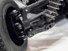 Close-up view of the suspension and wheel assembly of a remote-controlled vehicle. Voir les images du produit