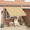 A retractable awning is installed above a window on a brick house, extending over a patio with outdoor furniture. Anteprima dell’immagine prodotto