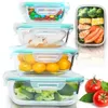 A collection of glass food storage containers filled with various food items, alongside fresh tomatoes and basil. Podgląd zdjęcia produktu