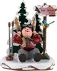 A figurine of a child in ski gear sitting in the snow next to a signpost. Produktbild-Vorschau