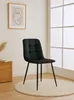 A black dining chair with tufted upholstery and black metal legs is placed on a round cream rug in a well-lit room. Náhľad obrázku produktu