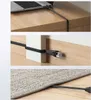 Three images showing a flat Ethernet cable being used in different scenarios: connected to a laptop on a desk, routed along a wall baseboard, and under a rug. Náhled obrázku produktu