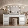 A modern bedroom with a white vanity table and stool in front of a bed. Produktbild-Vorschau