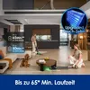 A modern living room with a woman using a wet dry vacuum cleaner, another woman sitting on the floor, and a dog. Produktbild-Vorschau