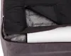 A close-up view of a dog bed with its cover partially unzipped, revealing the interior padding and a white cylindrical object. Produktbild-Vorschau