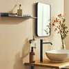 A modern bathroom vanity with a sink, faucet, soap dispensers, and a shelf with toiletries. Podgląd zdjęcia produktu