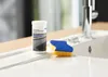 A bottle of cleaning product and a sponge are placed on the edge of a sink. Produktbild-Vorschau