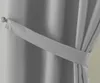 A close-up view of a gray curtain held back by a fabric tie. Produktbild-Vorschau