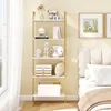 A white and gold ladder shelf filled with decorative items and folded linens, placed next to a bed in a bedroom. Produktbild-Vorschau