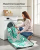 A woman is putting a blanket into a washing machine. Produktbild-Vorschau