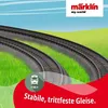 A cartoon-like illustration of toy train tracks curving through green grass under a blue sky with clouds. Produktbild-Vorschau