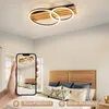 A modern bedroom with a wooden headboard and a ceiling lamp. Produktbild-Vorschau