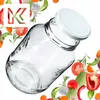 A clear glass jar with a white lid, surrounded by various fresh vegetables and herbs, suggesting preservation or canning. Anteprima dell’immagine prodotto