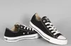 A pair of black Converse All Star low-top sneakers on a light gray background. Voir les images du produit