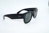 A pair of black sunglasses with green lenses is displayed against a white background. Voir les images du produit