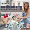 A woman stands next to a bicycle with a size chart overlayed on the image. Produktbild-Vorschau