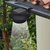 A solar-powered gutter light is attached to a gutter, illuminating the surrounding foliage. Produktbild-Vorschau