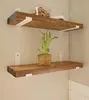 Two wooden shelves mounted on a light-colored wall, with a plant on the lower shelf. Produktbild-Vorschau