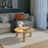 A living room scene with a couch, coffee table, and lamp. Voir les images du produit