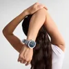 A person stretching their arm, wearing a smartwatch. Podgląd zdjęcia produktu