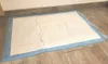 A pet training pad is laid out on a wooden floor. Produktbild-Vorschau