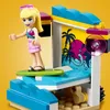 A LEGO Friends character is on a surfboard in a pool party setting. Produktbild-Vorschau