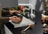 A person is washing a vase in a modern kitchen sink with a white faucet and a roll-up drying rack. Produktbild-Vorschau