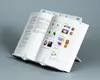 An open book is displayed on a white book stand against a light gray background. Náhled obrázku produktu