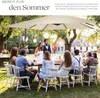 A group of people are gathered around a table outdoors, enjoying a meal under a large umbrella. Produktbild-Vorschau