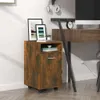 A small wooden cabinet with wheels is placed next to a desk in a home office setting. Náhľad obrázku produktu