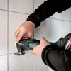 A person is using a Metabo multitool to cut grout between tiles. Náhľad obrázku produktu