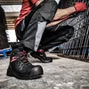 A person wearing work clothes and safety boots is crouching next to a metal grid. Voir les images du produit