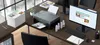 A Canon PIXMA G3560 printer is set up on a desk in an office environment, with printed documents, ink bottles, a computer monitor, and office supplies. Voir les images du produit