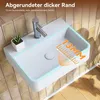 A white rectangular sink with a faucet and a small plant, set against a tiled wall and wooden floor. Náhled obrázku produktu