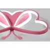 Close-up of a pink heart-shaped ceiling light with white LED lighting. Produktbild-Vorschau